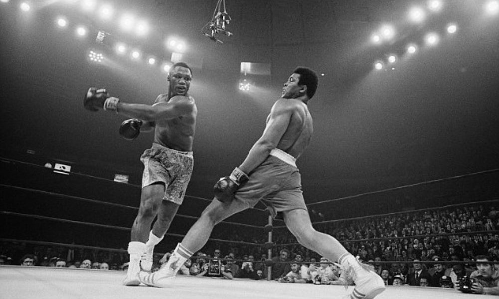 19710308. LA PELEA DEL SIGLO. El 8 de marzo, en el Madison Square Garden de la ciudad de Nueva York, el boxeador Muhammad Alí pierde por primera vez en su exitosa carrera al caer ante Joe Frazier por unanimidad de los jueces en la llamada “pelea del siglo”, una de las noches más recordadas de la historia del boxeo.